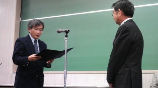 石本名誉理事が壇上へ上がり表彰状を授与